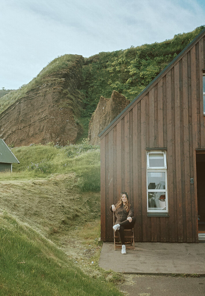 Rachel Bond sitting in front of Airbnb during their anniversary celebration in Iceland. 