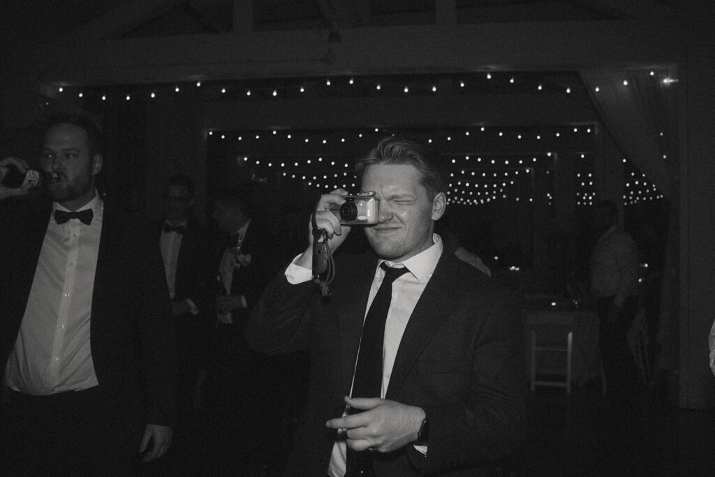 A wedding guest taking photos with a 35mm film camera