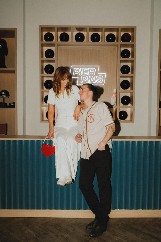 A New Jersey couple poses at a local bowling alley as they welcome guests to their wedding weekend at The Wave Resort 