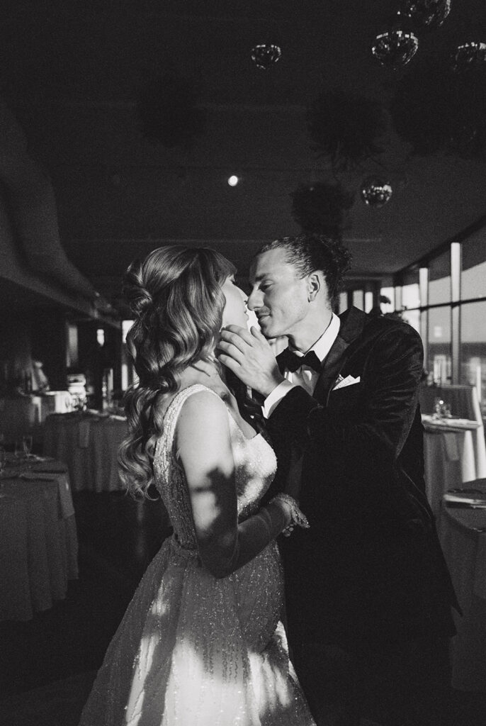 A black and white image shows an affectionate moment between a bride & groom at their Long Branch NJ wedding 