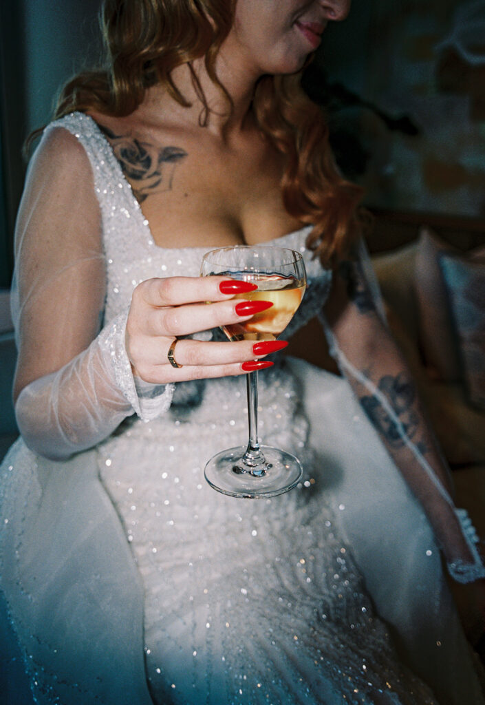 A close up image shows a bride holding a glass of white wine at her Long Branch NJ wedding 