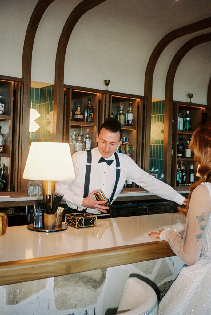 A film scan shows a groom behind the bar at The Wave Resort preparing a drink for his new bride 