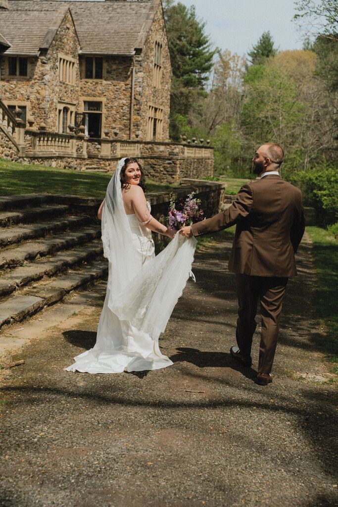 A groom assists his bride with the train of her gown at  parque wedding venue