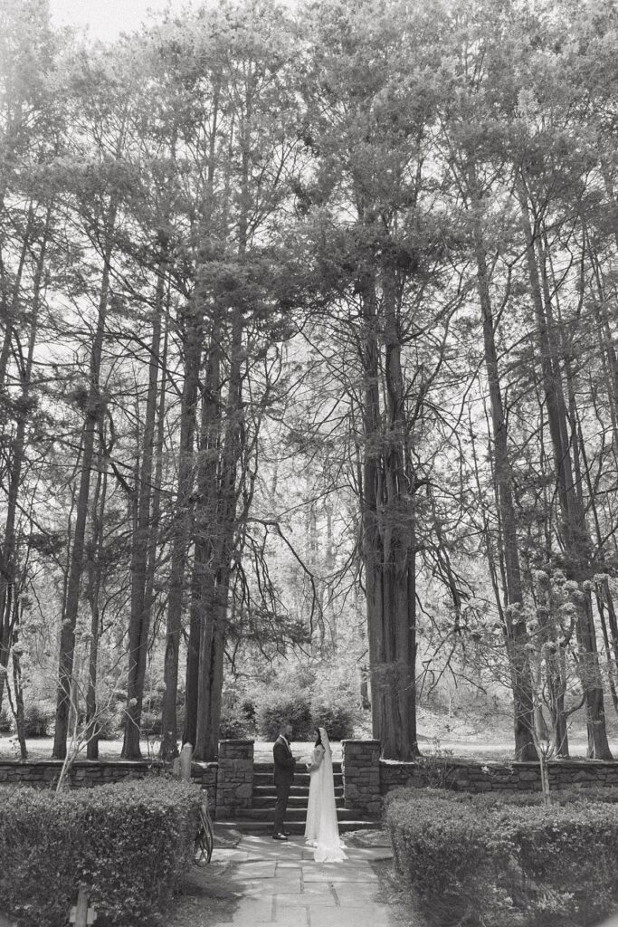 A b+w image of a bride and groom exchanging private vows from a distance at their ridley creek wedding