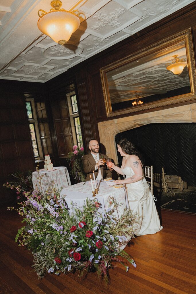 A bride and groom cheers at their wedding reception held at ridley creek state park mansion