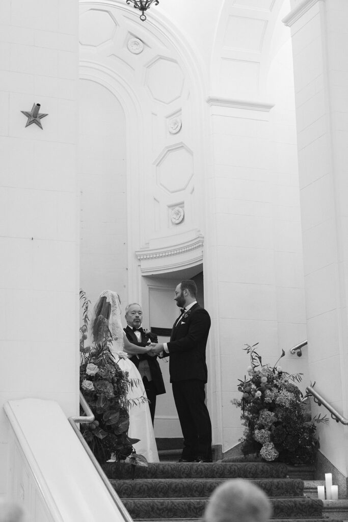 Rings are exchanged in a black and white photo taken at an art museum philadelphia wedding