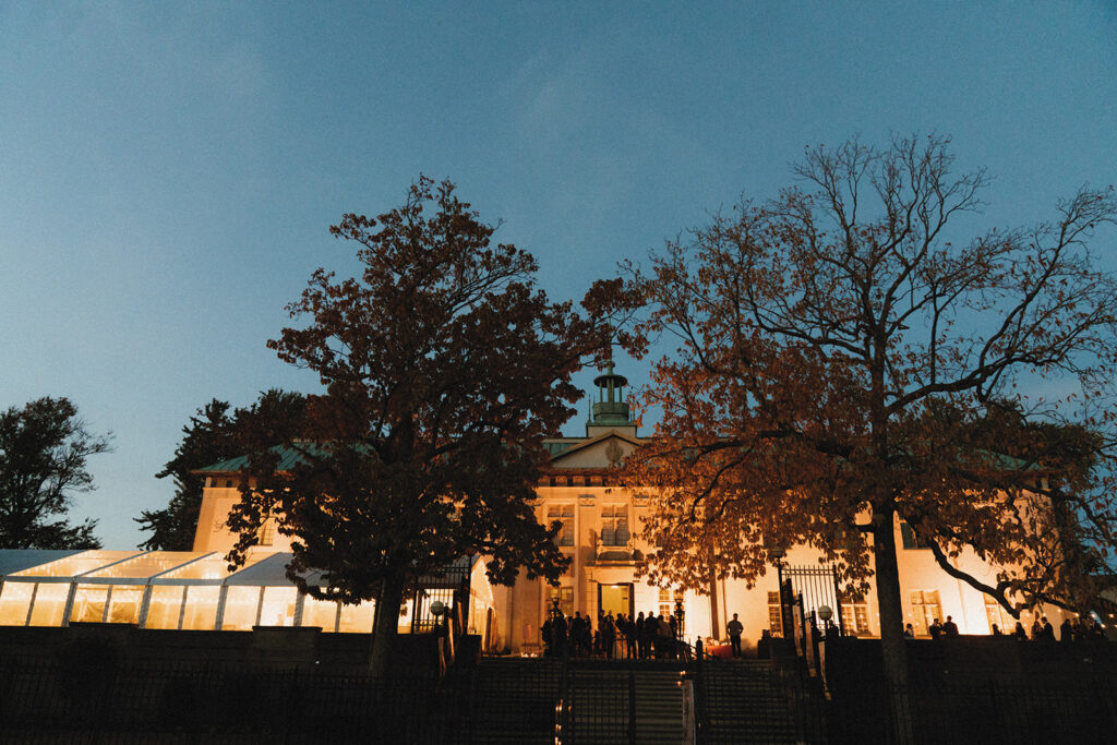An american swedish historical museum wedding is photographed from the exterior of the building at dusk